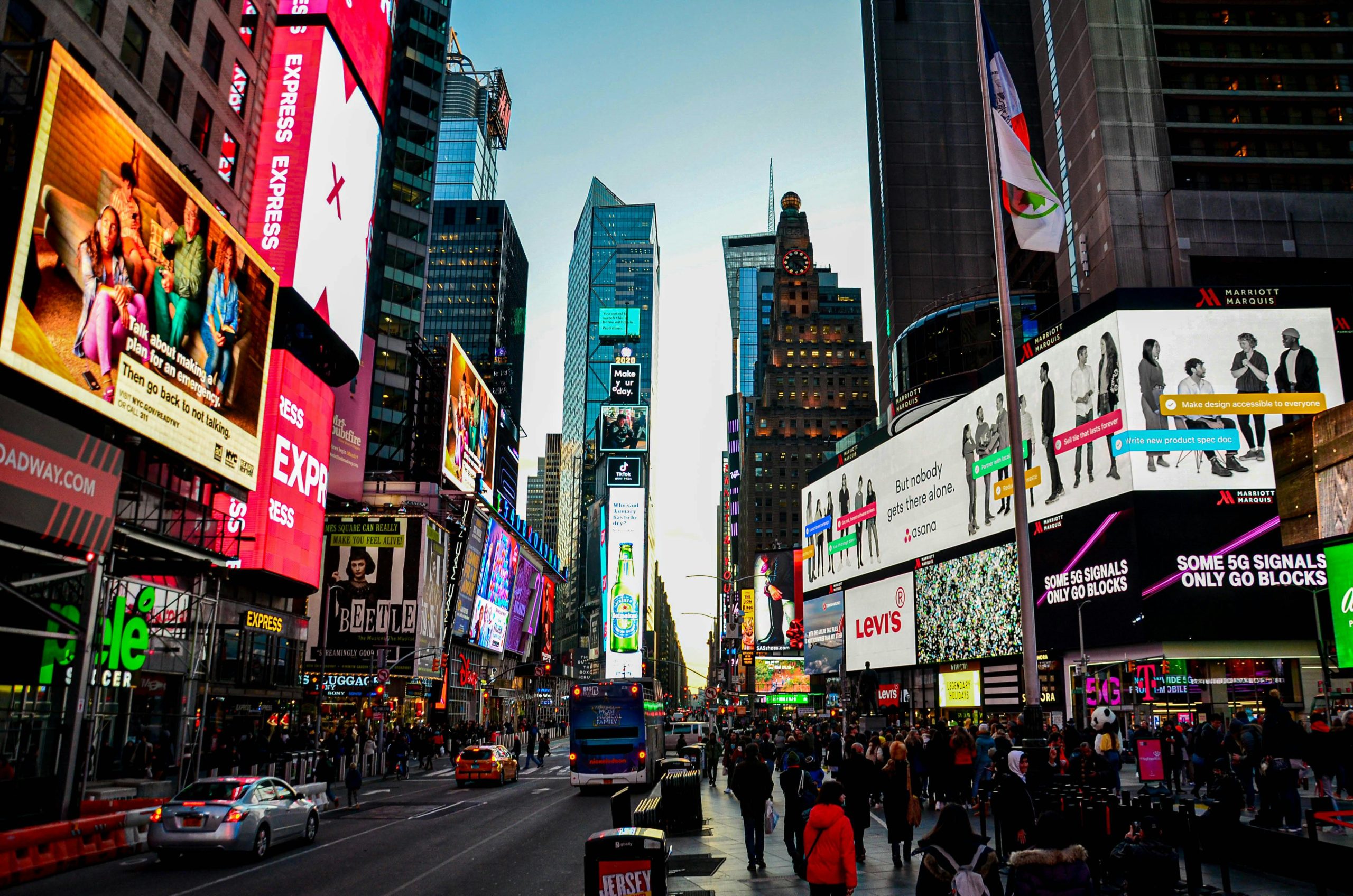 Dynamic cityscape of Times Square, New York, bustling with lights and activity at dusk.